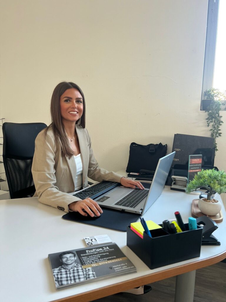 Frau arbeitet an Laptop im Büro, professionelle Rohrreinigungsfirma.